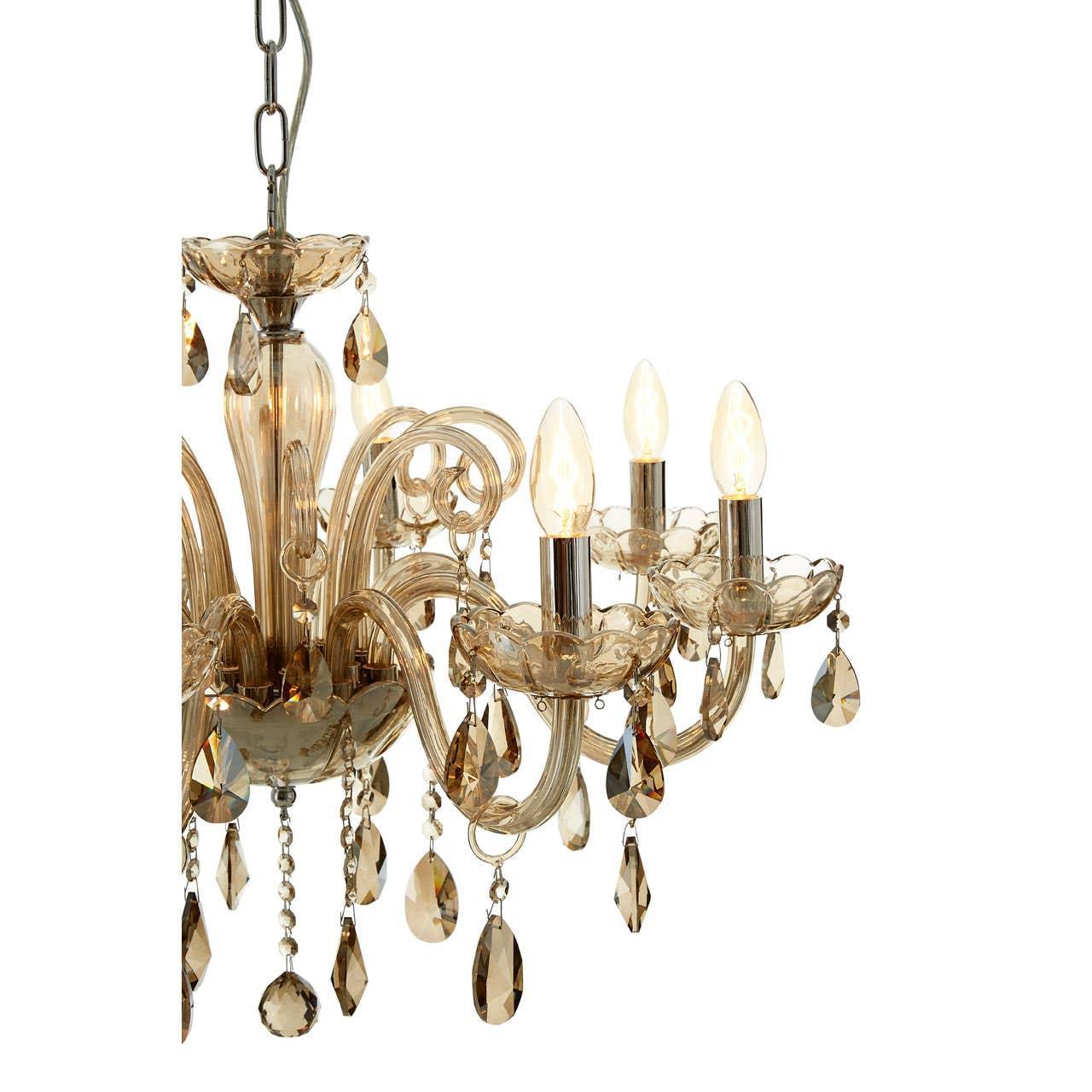 Gold glass chandelier with crystal droplets and candle-style lights against white background