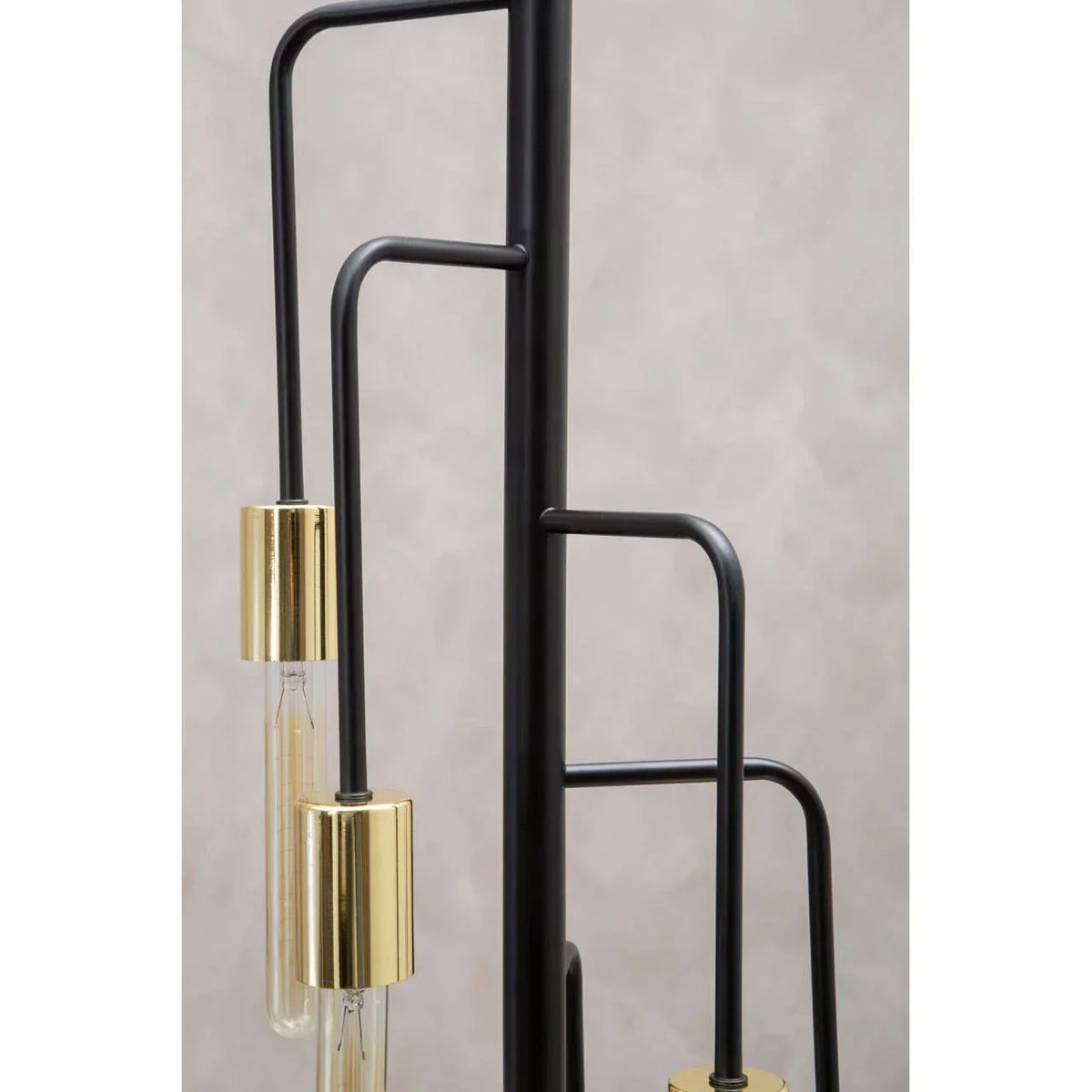 Modern black metal floor lamp with gold lamp holders and exposed bulbs, close up