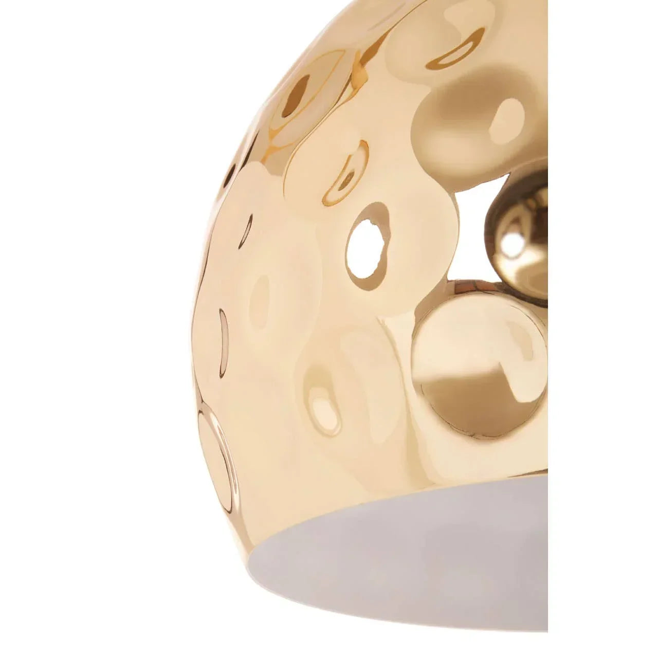 Closeup of gold metal pendant light shade with circular cutout design