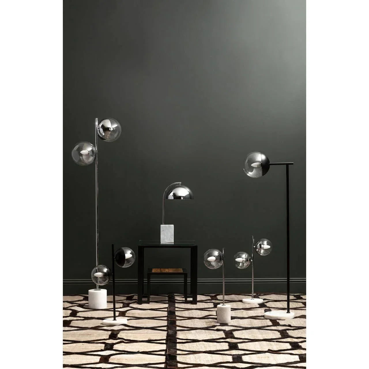 Contemporary chrome floor and table lamps with marble bases on geometric patterned rug