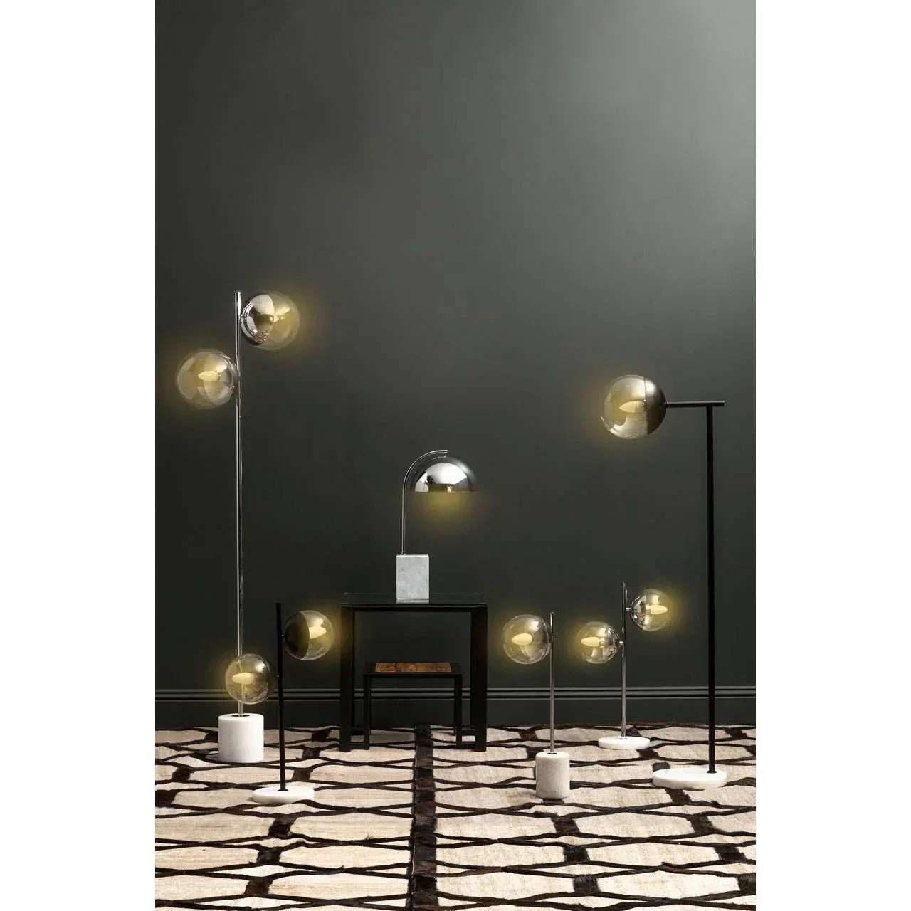 Modern floor and table lamps with glass globes and marble bases on patterned rug