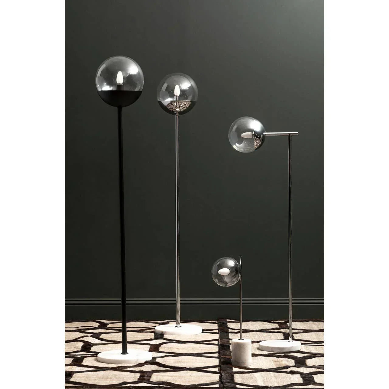 Set of modern floor lamps with glass globes and marble bases on patterned rug