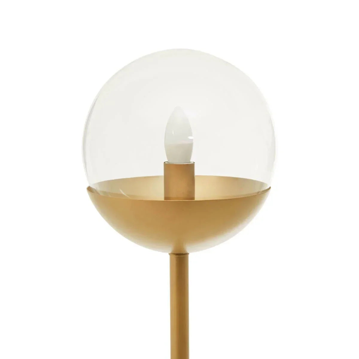 Gold floor lamp with clear glass globe shade and visible bulb on white background