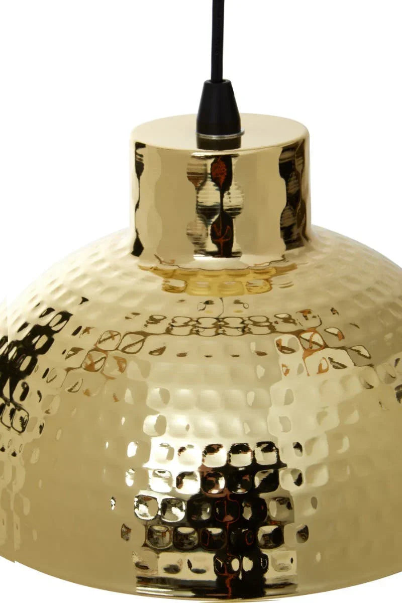 Gold hammered metal pendant light with black cable, close-up of textured dome shade