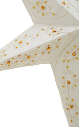 White paper star lantern with gold beaded floral decoration, close-up view of one point