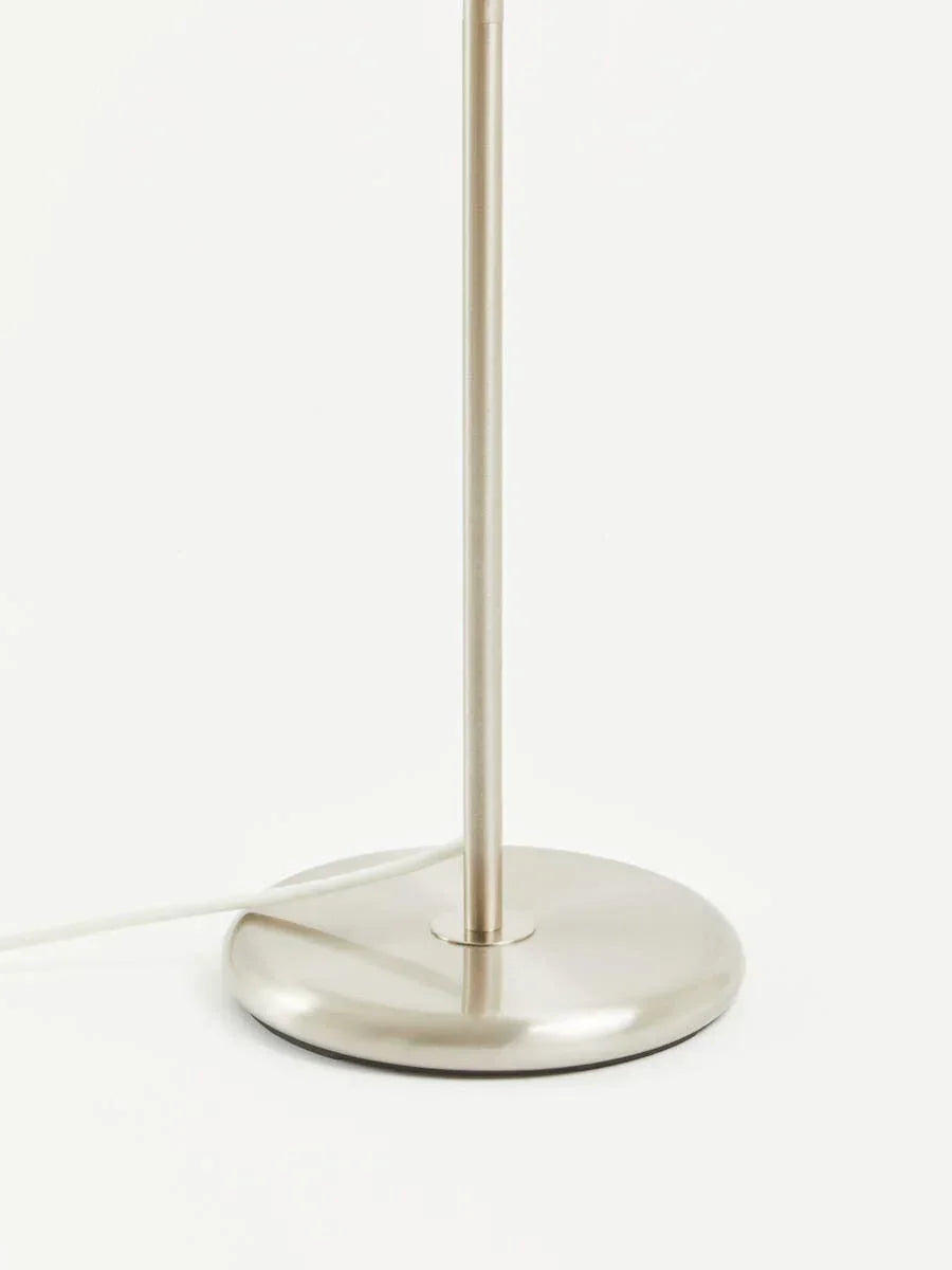 Brushed metal lamp base with round shape and vertical stand, visible power cord on white surface