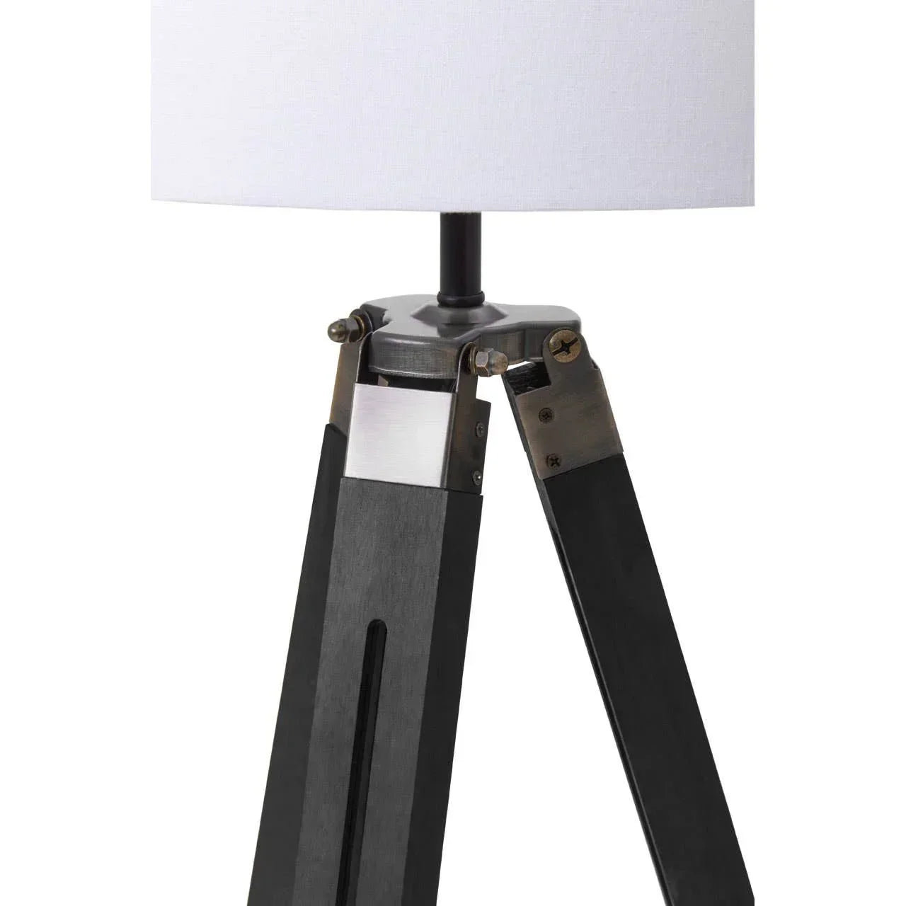 Tripod table lamp with white fabric shade and black wooden legs, close-up view
