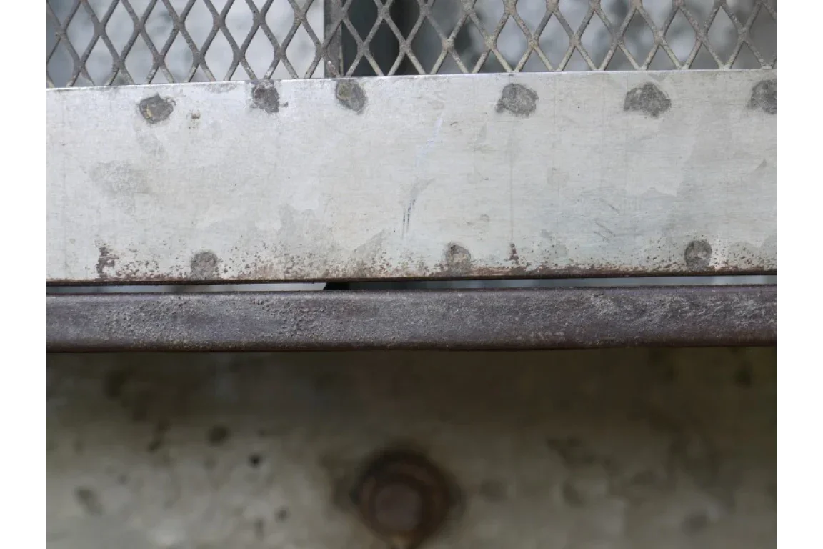 Close up of metal panel with bolts and mesh, industrial furniture material detail