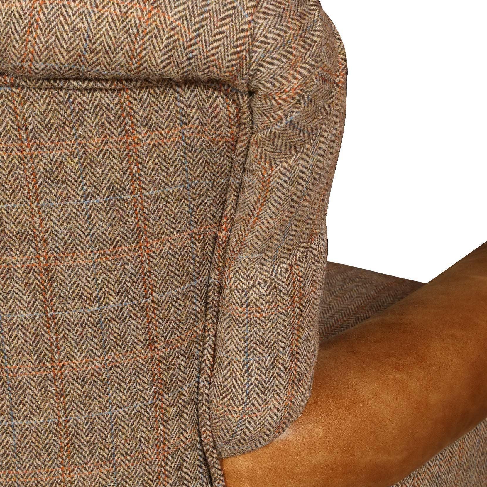 Closeup of tweed armchair with brown leather accent on armrest
