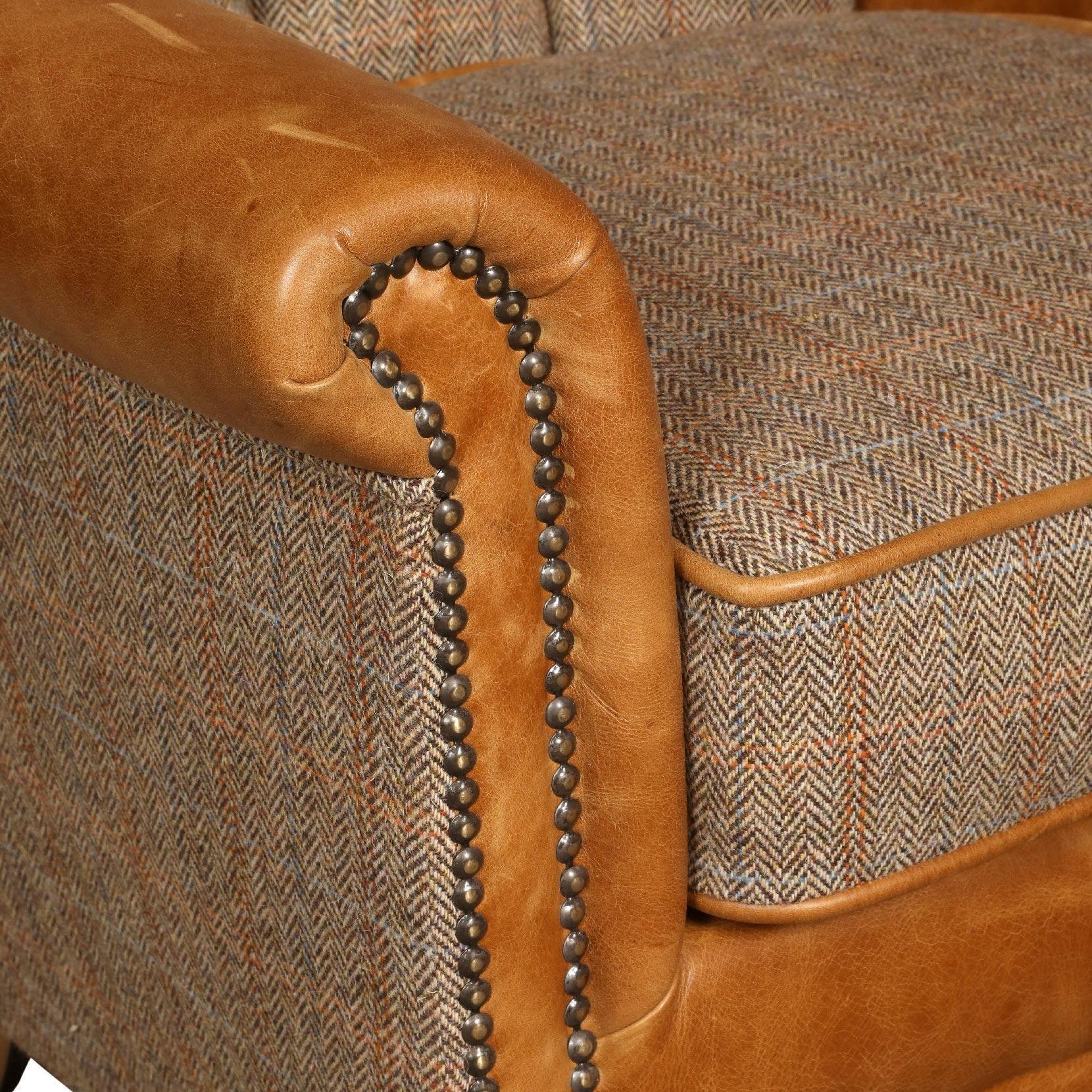 Close-up of brown leather and tweed armchair with studded trim