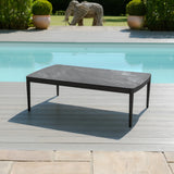 Black outdoor coffee table with metal frame on decking by a swimming pool