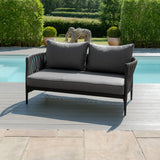 Grey outdoor garden sofa with rope detail and metal frame by a swimming pool