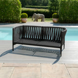 Black outdoor garden sofa with slatted design on poolside decking