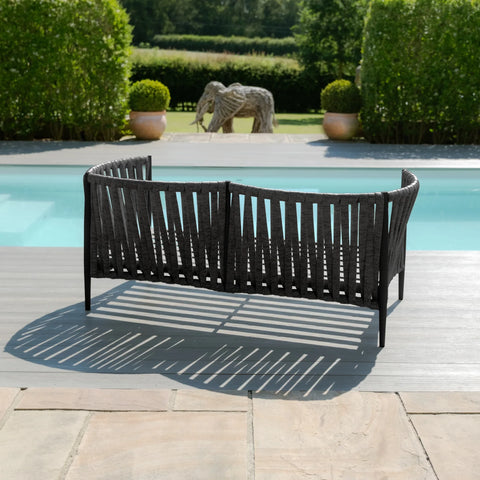 Black outdoor garden sofa with woven design placed on poolside patio