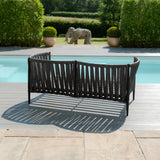 Black outdoor garden sofa with woven design placed on poolside patio