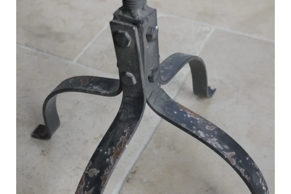 Black metal furniture leg with vintage rusted finish on tiled floor