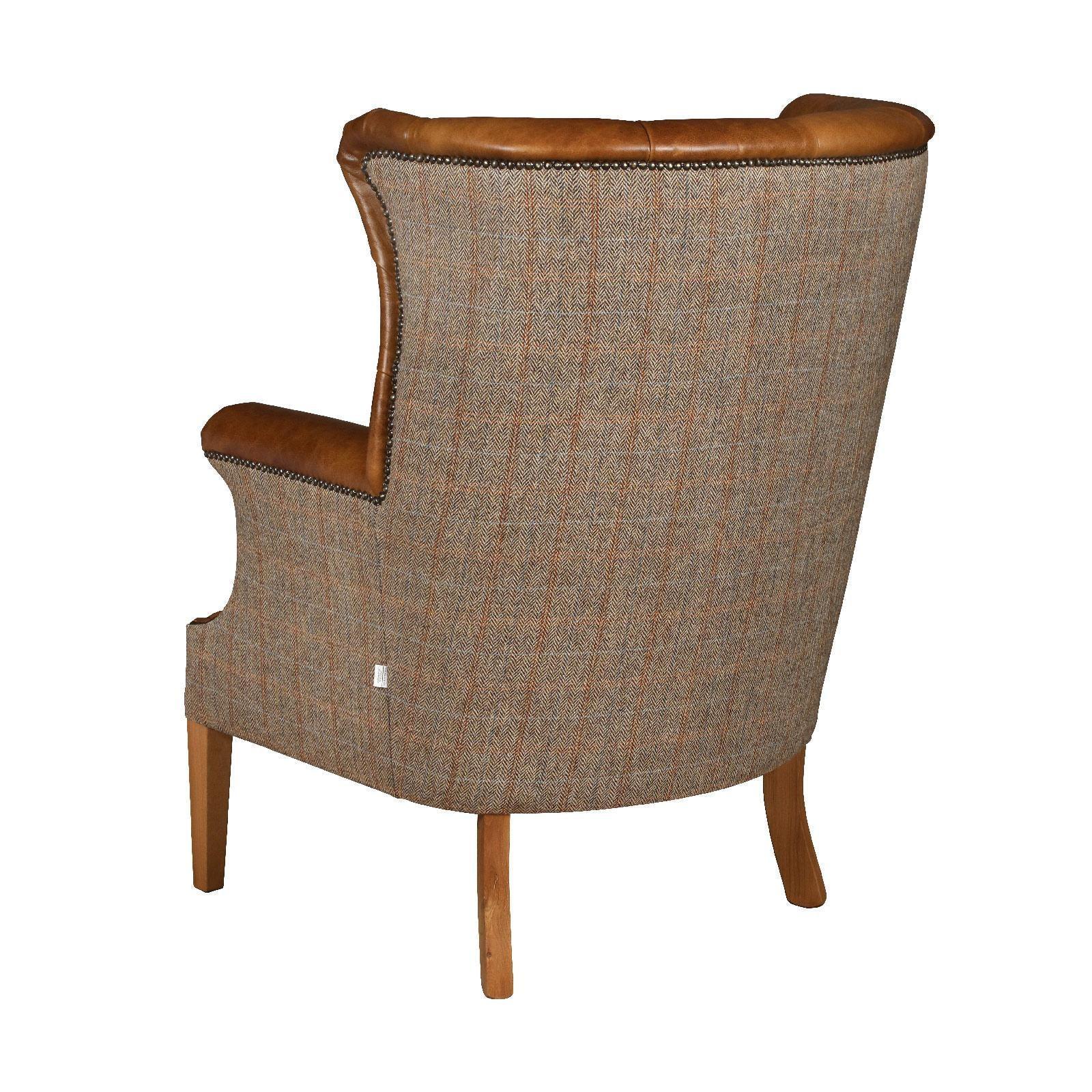 Back view of tweed armchair with tan leather trim and wooden legs