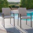 Pair of outdoor dining chairs with grey cushions beside a swimming pool on decking