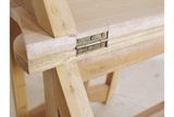 Close-up of unfinished light wood chair step detail showing metal hinge and natural wood grain angle view.