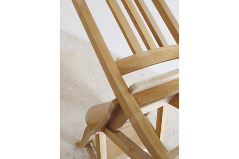 Unfinished wooden chair with slatted back and step stool feature, angled view on light stone floor.