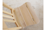 Unfinished light wood chair with a hinged seat viewed from above on a tiled floor.