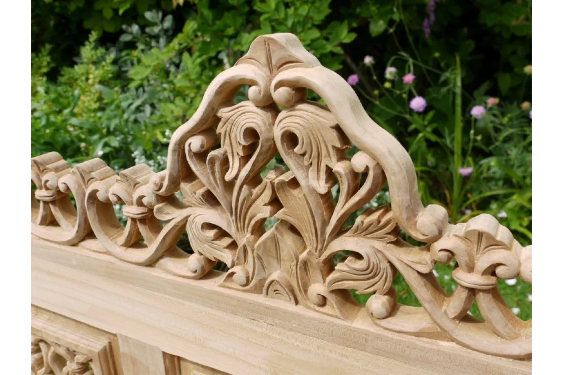 Teak garden bench with ornate carved wood backrest in outdoor setting