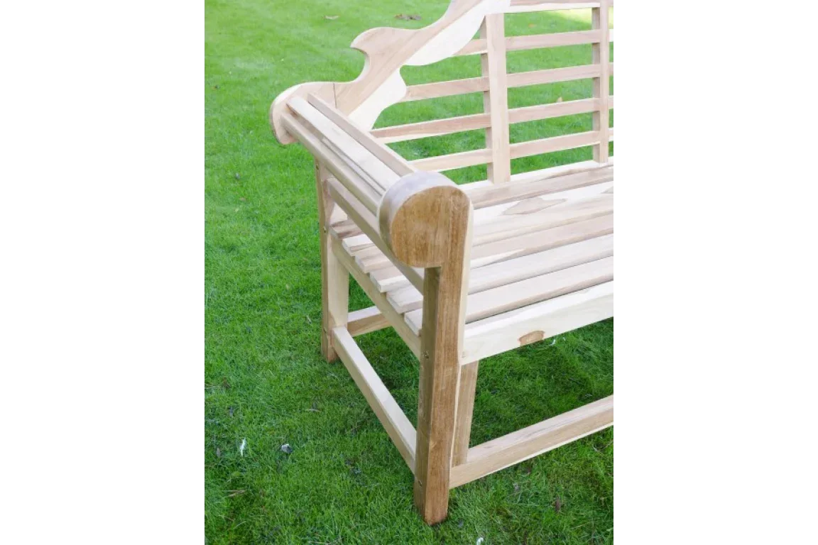 Close up of wooden garden bench armrest and slatted back on grass