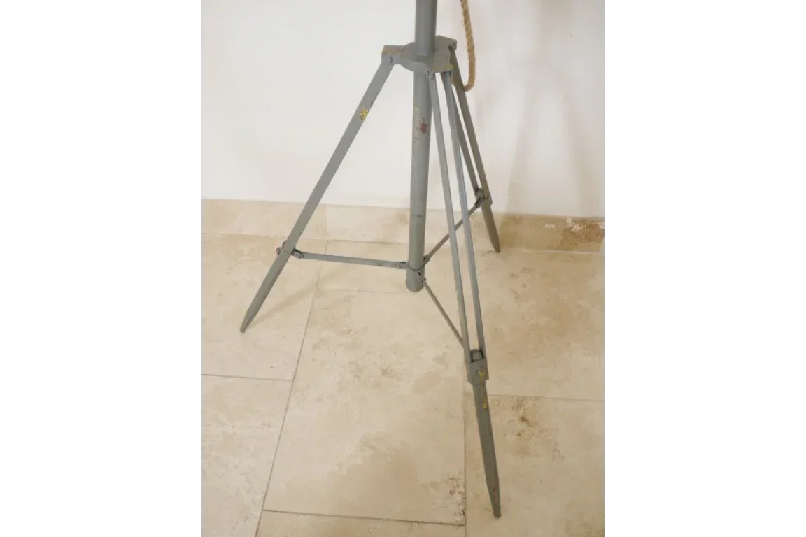 Grey metal tripod floor lamp base with rope detail on light tiled floor