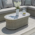 Rattan outdoor coffee table with glass top, vase, drinks and snacks, on patio with sofa