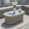 Rattan outdoor coffee table with glass top, vase, drinks and snacks, on patio with sofa