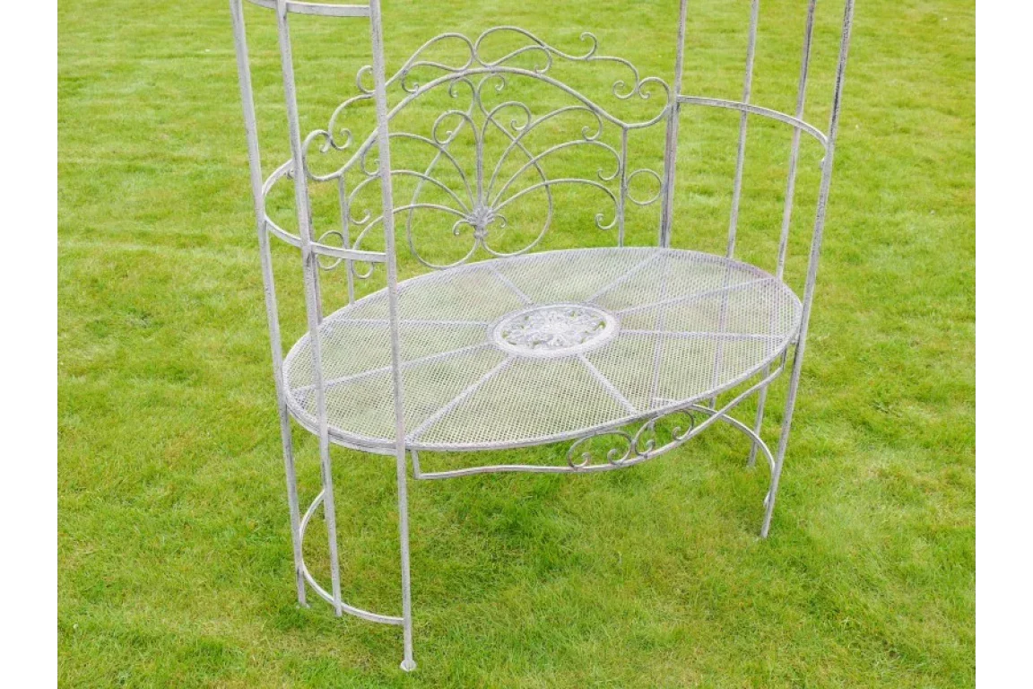 Decorative metal garden bench with ornate scrollwork on green lawn
