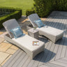 Rattan sun loungers with cream cushions and blue striped pillows on decking patio