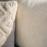 Closeup of beige fabric sofa cushion with textured cream throw pillow