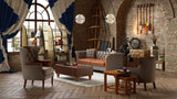 Modern living room with brown leather sofa, armchairs, ottoman coffee table, and brick walls