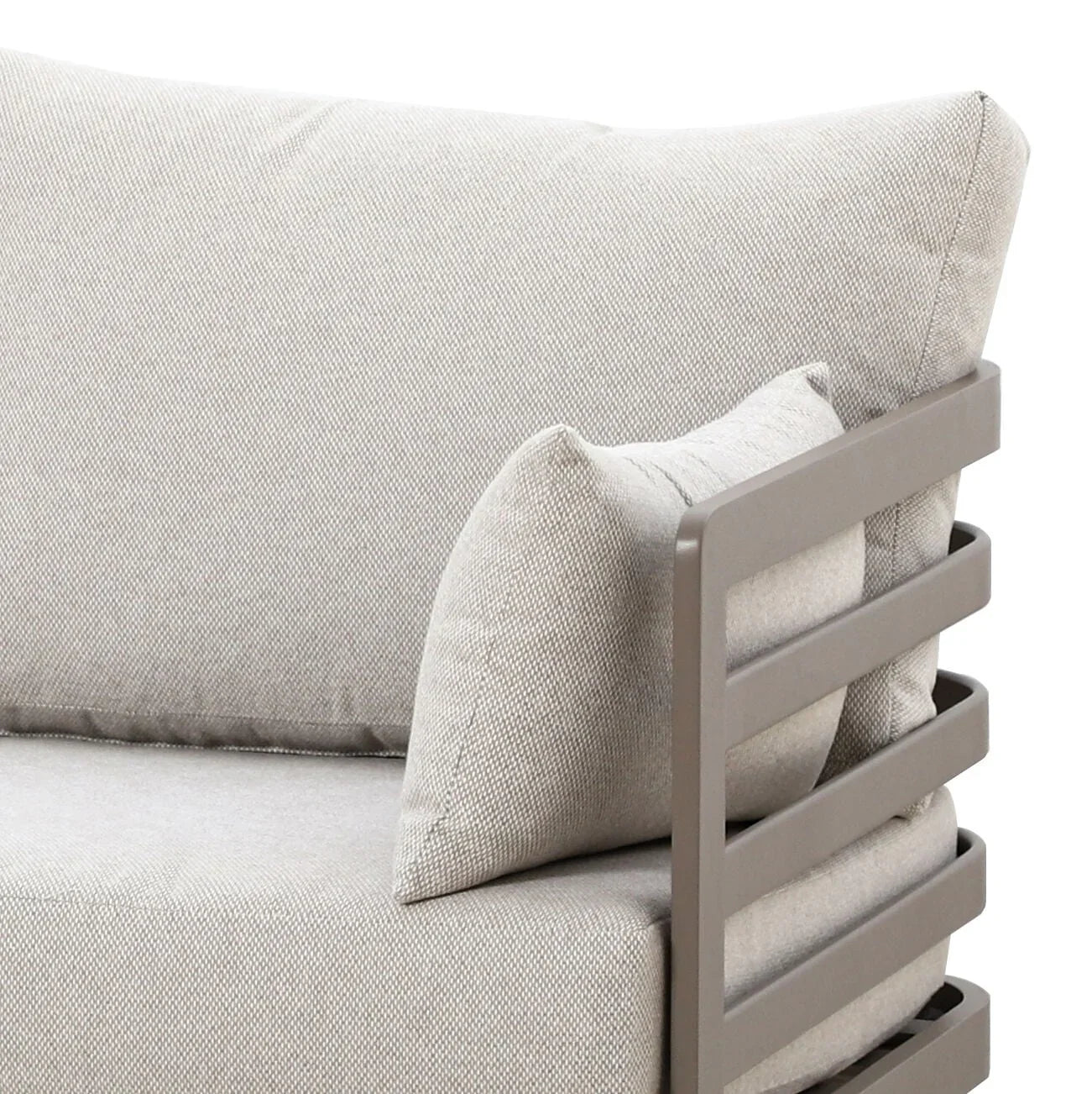 Beige fabric sofa armrest with metal frame and matching throw pillow close-up