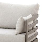Beige fabric sofa armrest with metal frame and matching throw pillow close-up