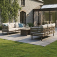 Outdoor patio furniture set with cream cushions and coffee table on stone terrace