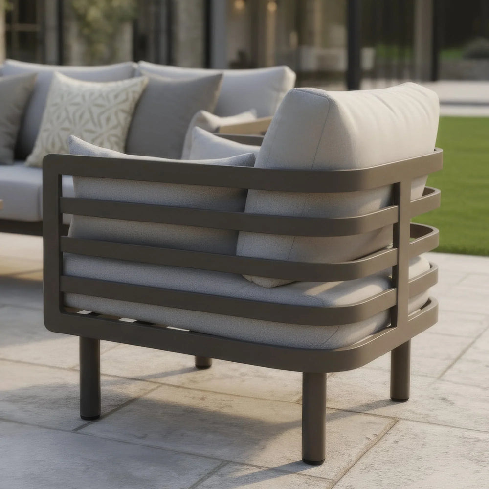 Modern outdoor garden armchair with metal frame and grey cushions on patio