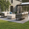 Beige outdoor sofa set with metal frame and cushions around a stone coffee table on patio