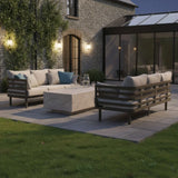 Modern outdoor sofa set with beige cushions and stone coffee table on a patio