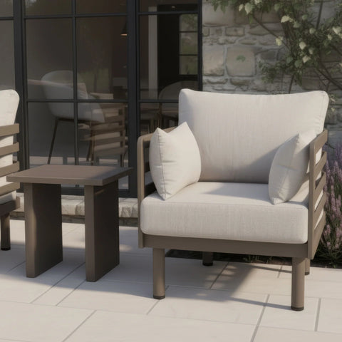 Outdoor armchair with beige cushions and matching side table on modern patio