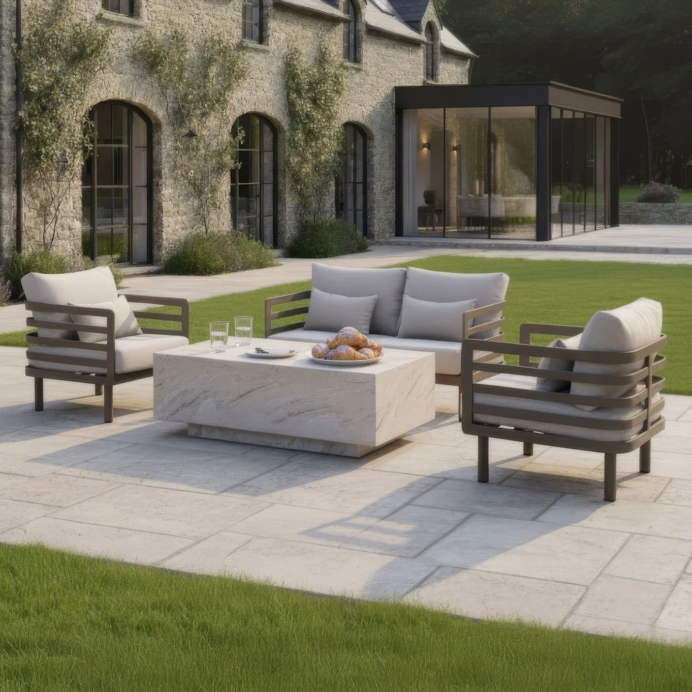 Outdoor patio sofa set with cream cushions and modern stone coffee table on paved terrace