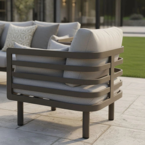 Outdoor lounge chair with light grey cushions and metal frame on patio
