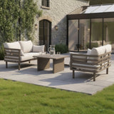 Modern outdoor sofa set with beige cushions and coffee table on stone patio