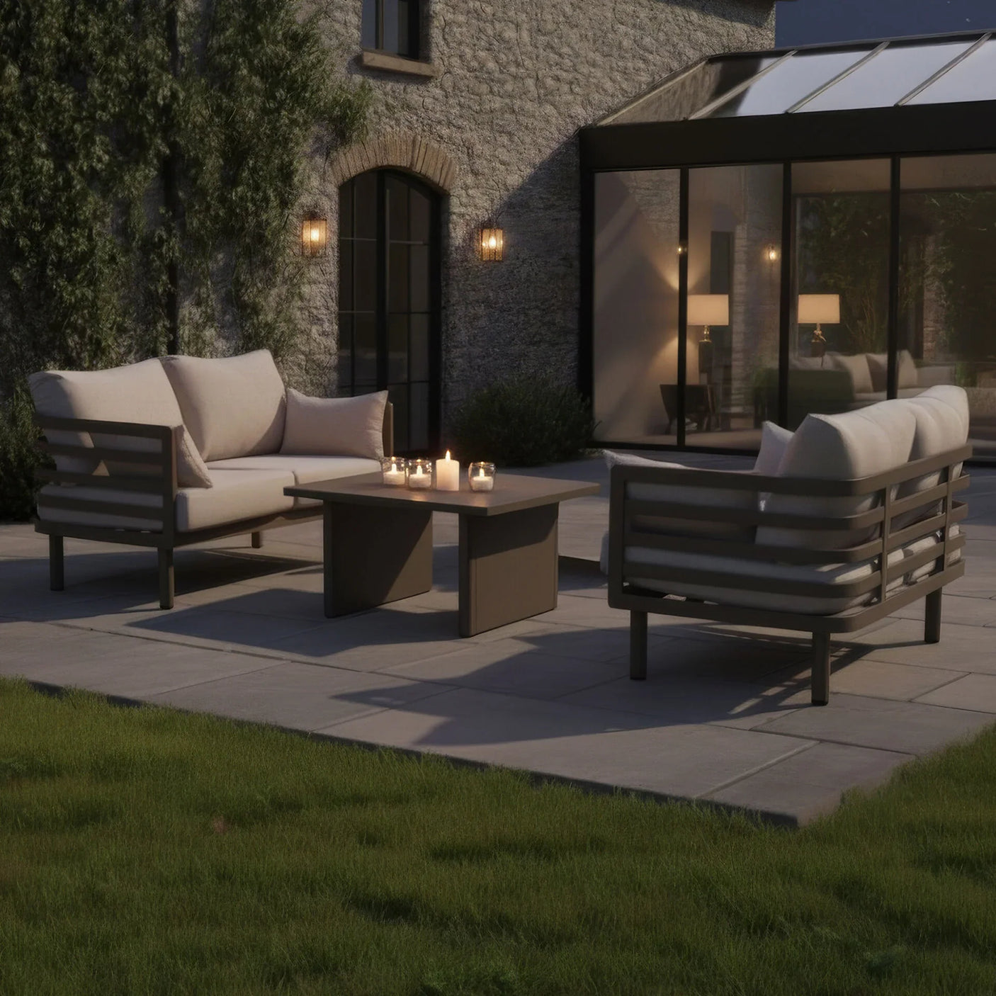 Beige outdoor sofa set with matching coffee table and candles on patio