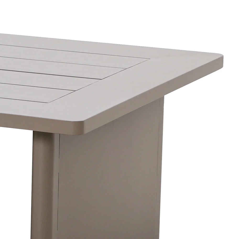 Close view of beige wooden dining table corner with slatted top and sturdy leg