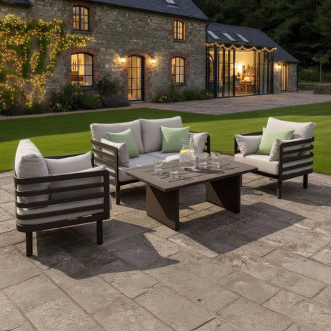 Modern outdoor garden furniture set with cushioned seats and coffee table on stone patio
