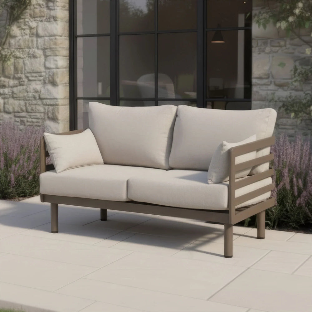 Outdoor garden sofa with beige cushions and wooden frame on patio