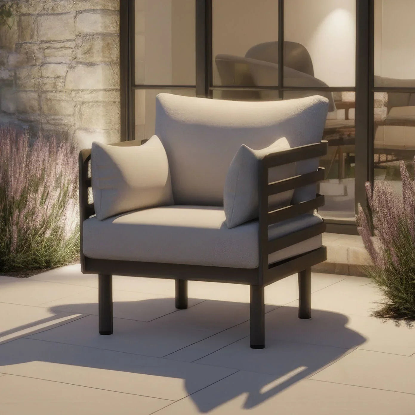 Outdoor armchair with grey cushions and black metal frame on patio