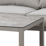 Grey fabric corner sofa with thick cushions next to modern stone effect coffee table